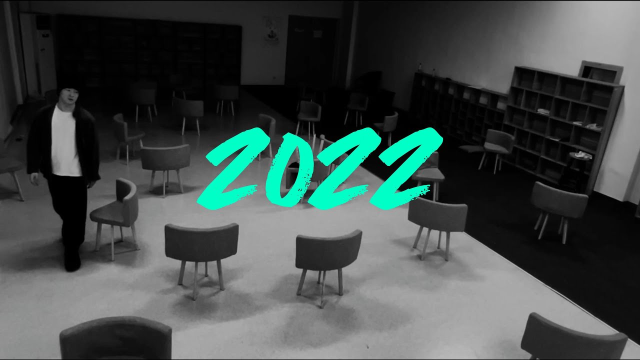 Black-and-white 2022 poster showing a performer among scattered chairs