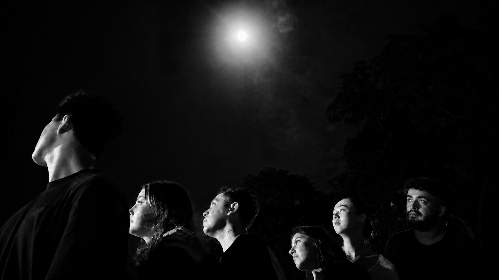 The touring company looking up at the moon at night