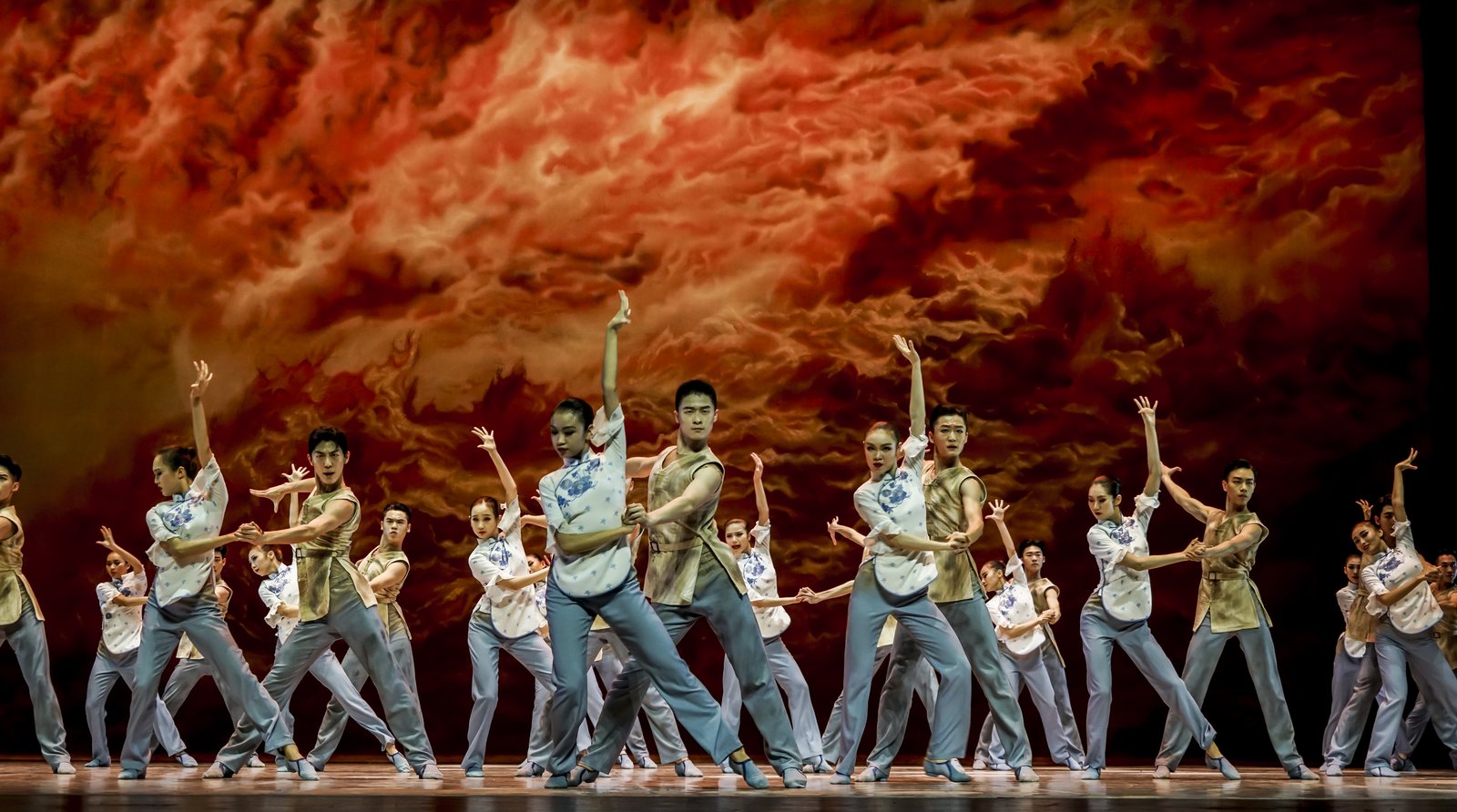 The company of The Yellow River in a large ensemble sequence beneath a red sky